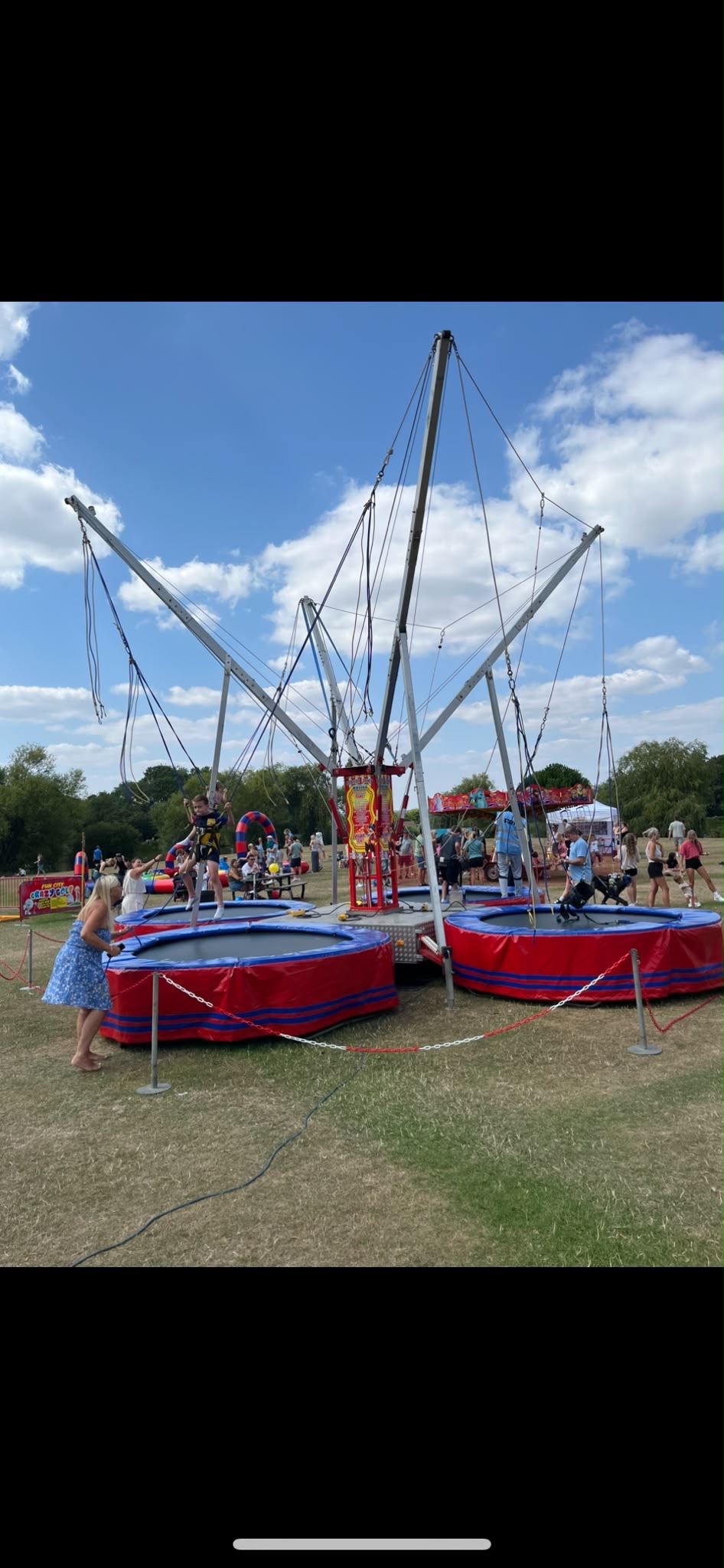 Children on a four-way bungee trampoline rig bouncing with harnesses