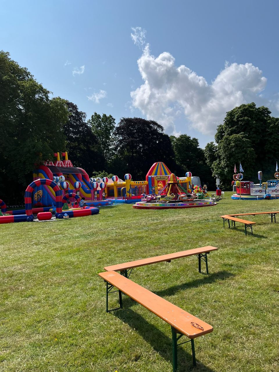 A wide panorama of a fun day with a slide, welcome arch and train ride