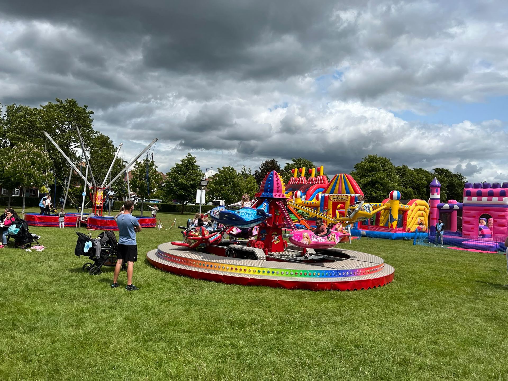 A big top inflatable, flying chairoplane ride and crowds of families enjoying a Bonds Leisure fun day under a dramatic Essex sky