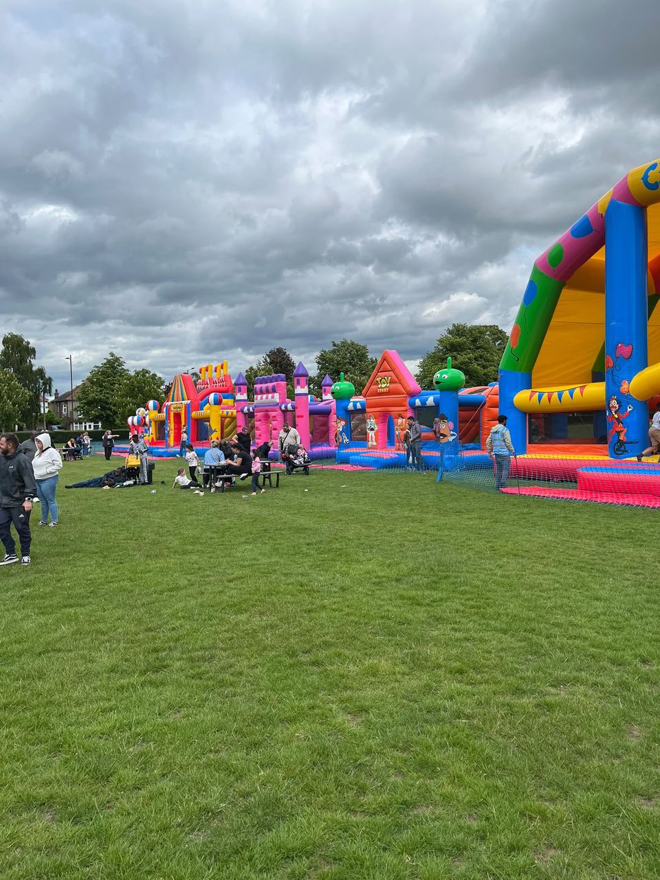 A row of large themed inflatables on a sunny playing field