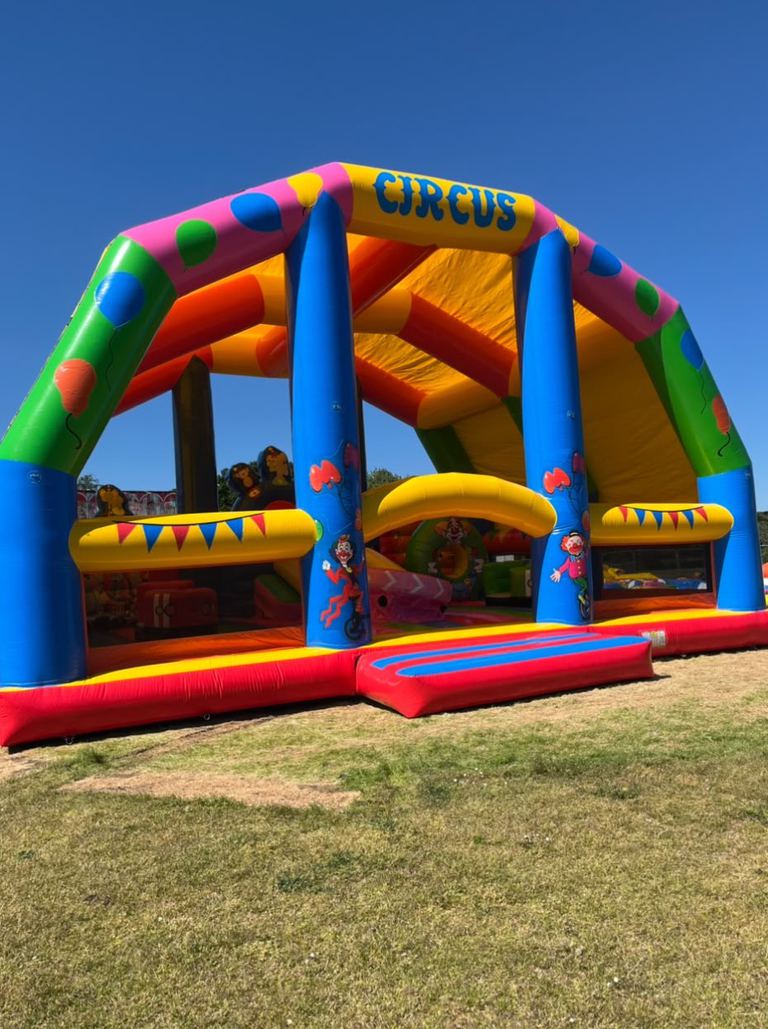 A large circus-themed inflatable arch and bounce area