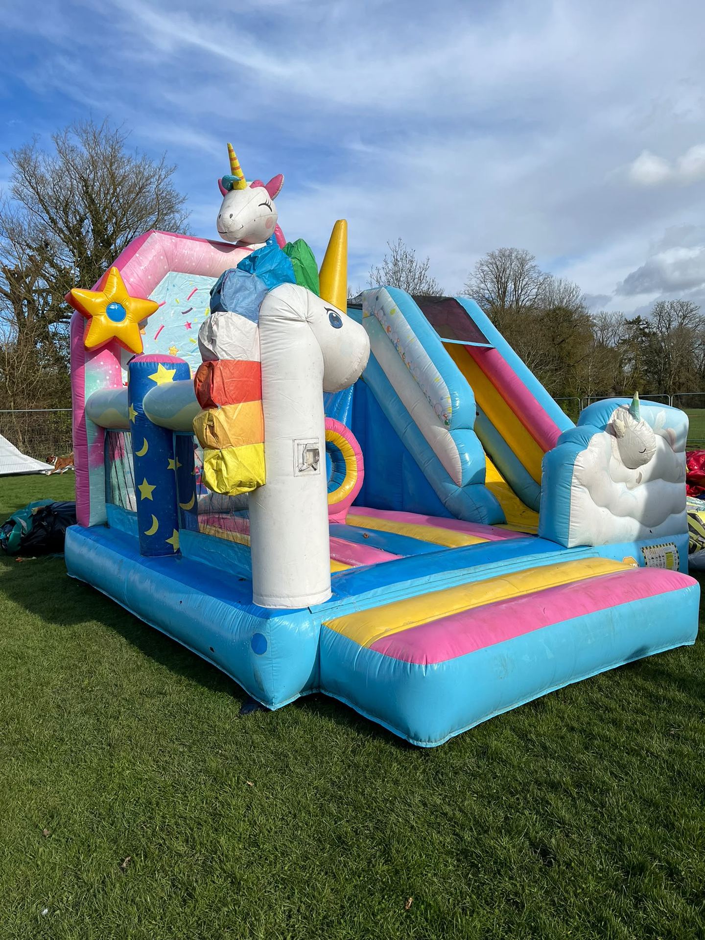 A unicorn-themed bouncy castle with an integrated slide