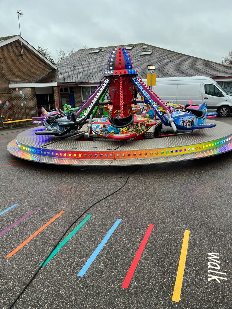 A spinning aeroplane ride set up in a school playground