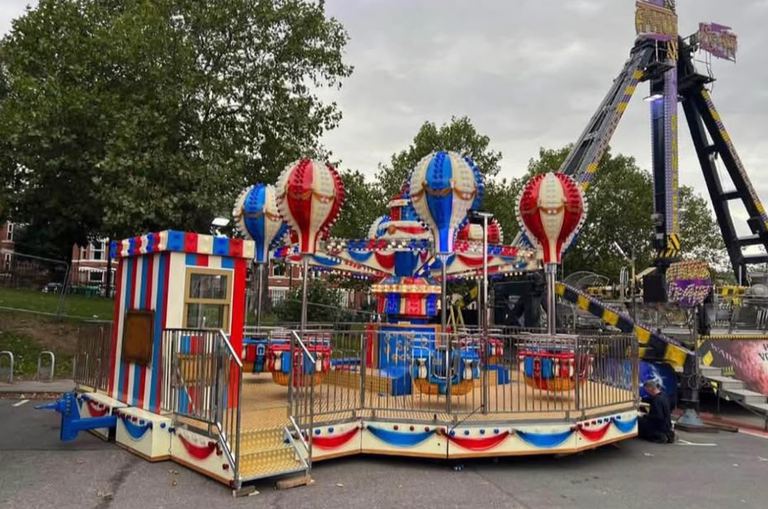 A hot air balloon themed fairground ride with red, white and blue balloon cars