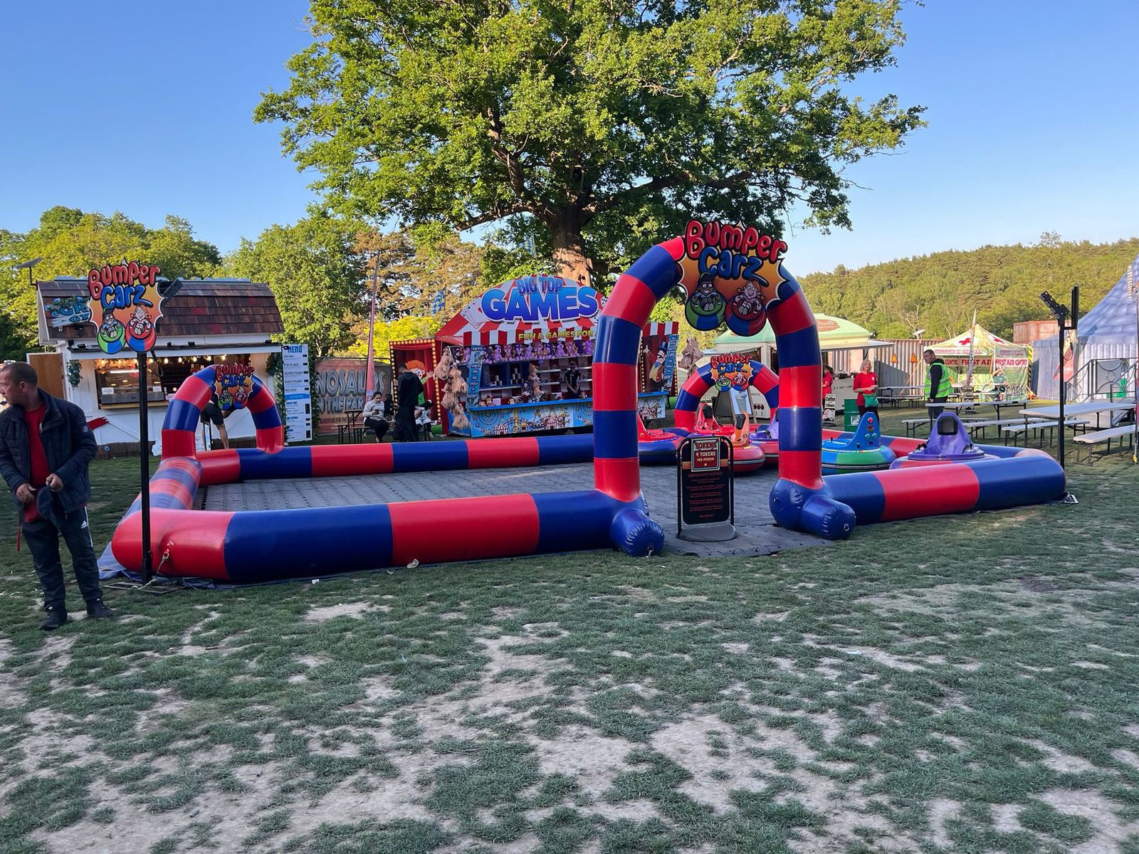 An inflatable bumper cars track with children riding battery bumper cars inside