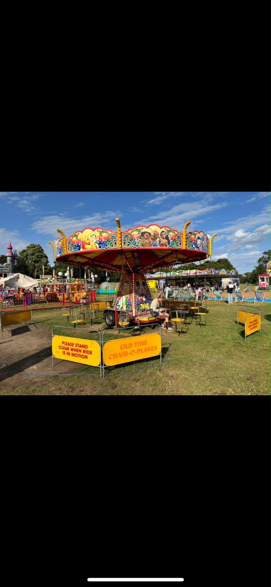 A vintage-style chairoplane ride with hanging seats spinning around a central column