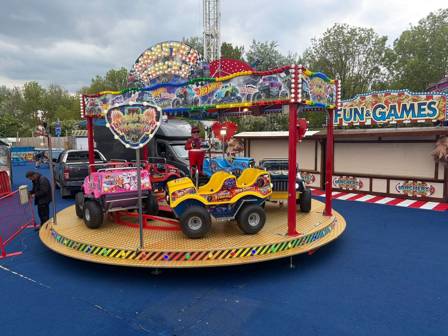 A kids' Monster Trucks ride with themed monster truck cars on a lit turntable