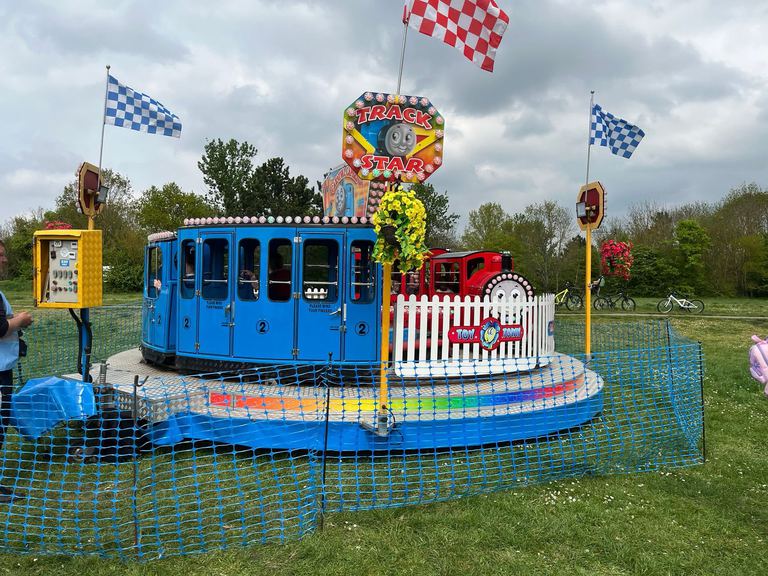The Toy Town train ride with cyclists passing in the background